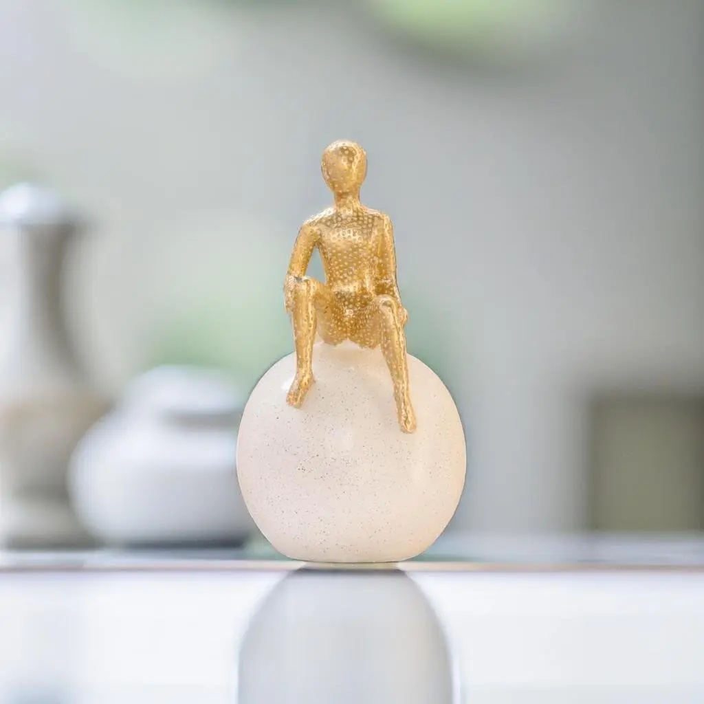abstract-gold-figure-sitting-on-white-sphere.jpg